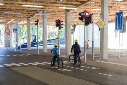 Two children on bicycles learning how to behave in traffic on a bicycle course 